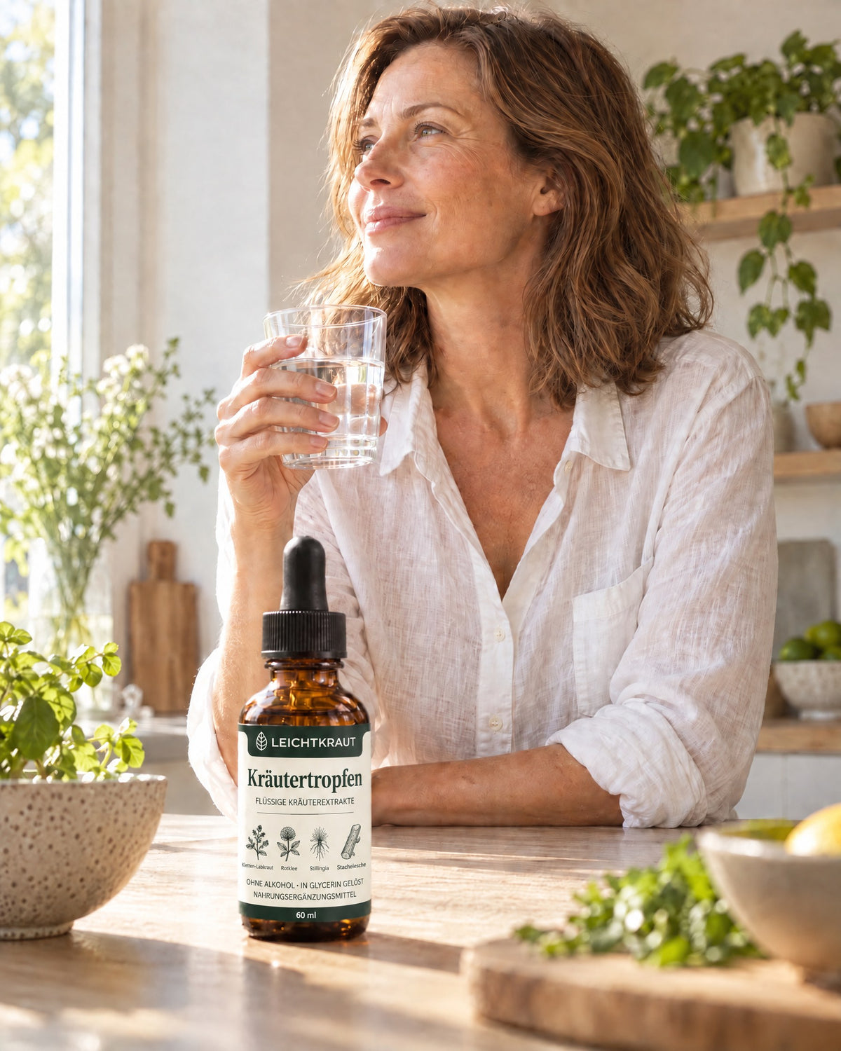 Frau mit einem Glas Wasser in der Küche, Leichtkraut Flasche auf der Arbeitsfläche